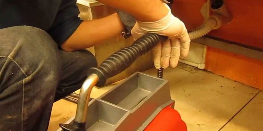Odunpazarı — Eskişehir gider açma — turuncu üniformalı tesisatçı kırmızı spiral makineyle mutfak gider hattı temizliyor
